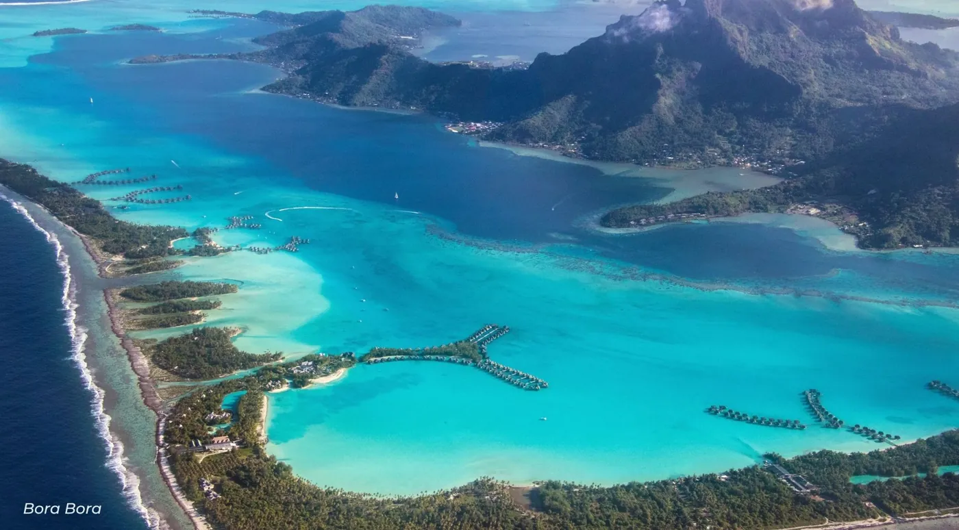 Aerial view of the Bora Bora lagoon, barrier reef motus and the main island