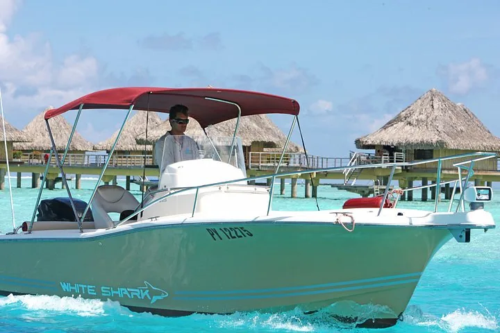 White Shark motorboat with a red canopy passing overwater bungalows