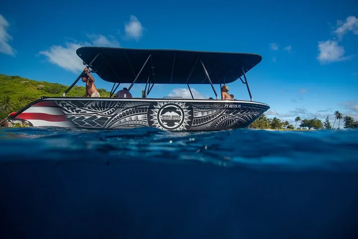 Shaded snorkel boat with a tribal-pattern hull at the water line