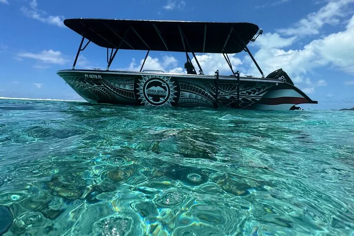 Covered snorkel boat anchored in shallow turquoise lagoon water