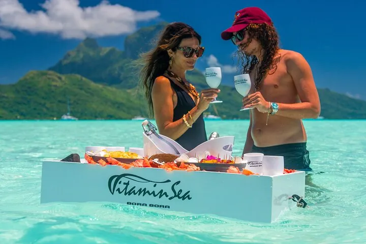 Couple sharing drinks at a floating bar of snacks in shallow water