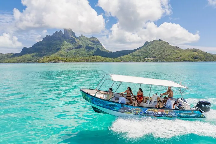 Guests aboard a covered boat cruising past Mount Otemanu