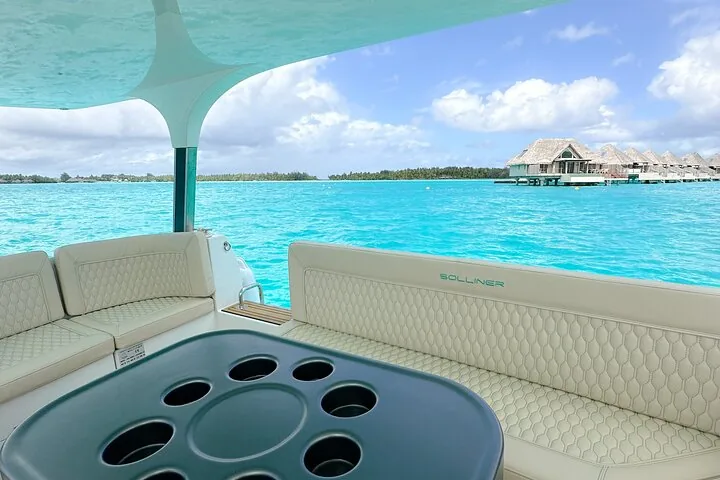 Cream leather seating on deck facing a row of overwater bungalows