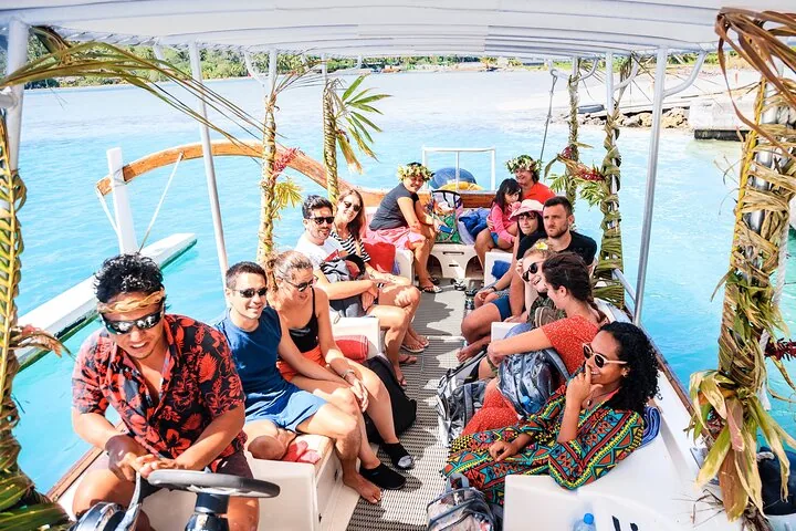 Guests seated on a covered boat decorated with palm fronds and flowers